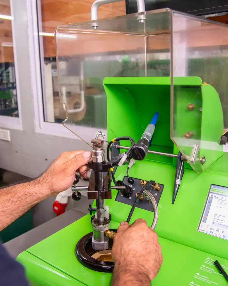 Técnico probando un inyector diésel en un banco de pruebas de taller